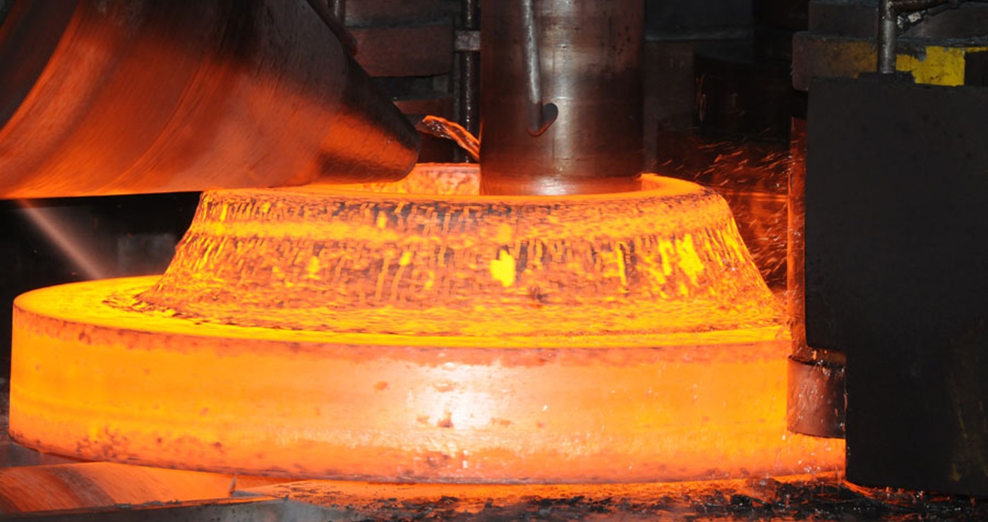 Forging press shaping a steel flange billet